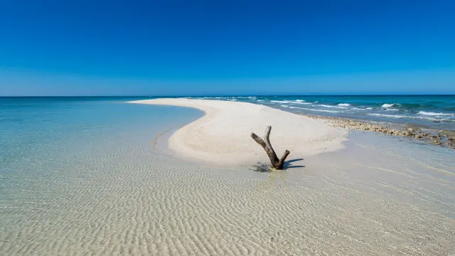 Curved White Sandbar Spit Enclosing Shallow Azure Basin at Low Tide