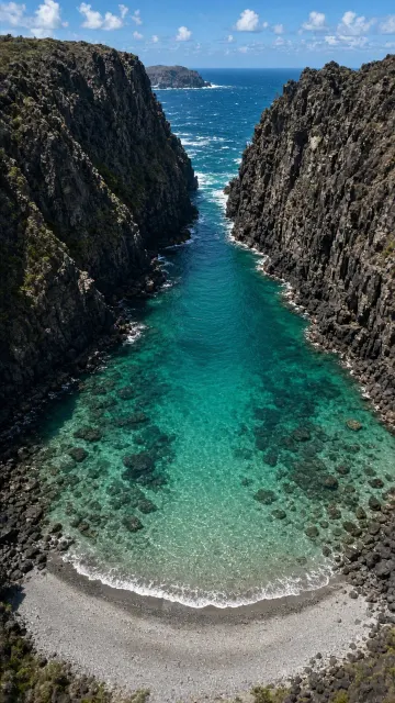 Vertical Aerial Perspective of Hidden Bay Lagoon Enclosed by Towering Volcanic Bluffs