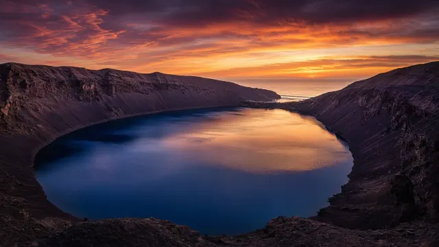 Sunset View Across a Drowned Volcanic Caldera Lagoon with Distant Sea Breaches