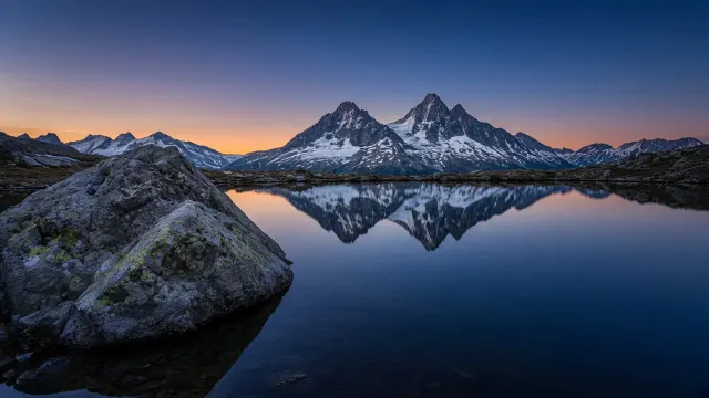 Still Alpine Tarn and Granite Boulder with Vast Twilight Sky
