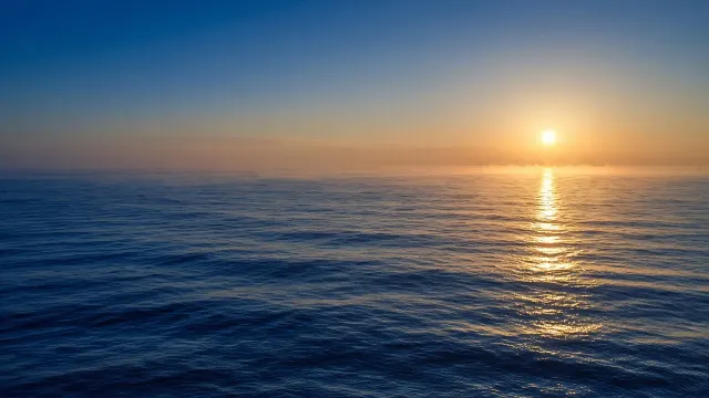 Low Golden Sun Glare Across Gentle Deep Blue Swells