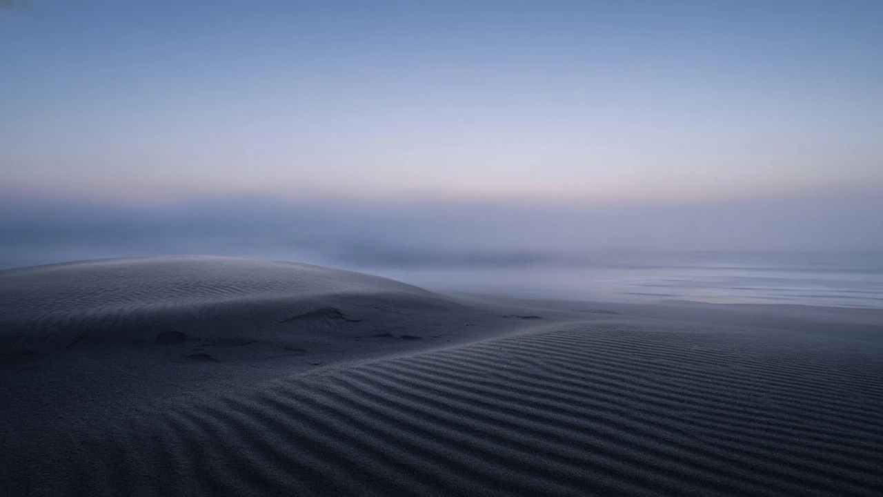 Solitary Twilight Coastal Sand Ridge Emerging into Quiet Sea Mist